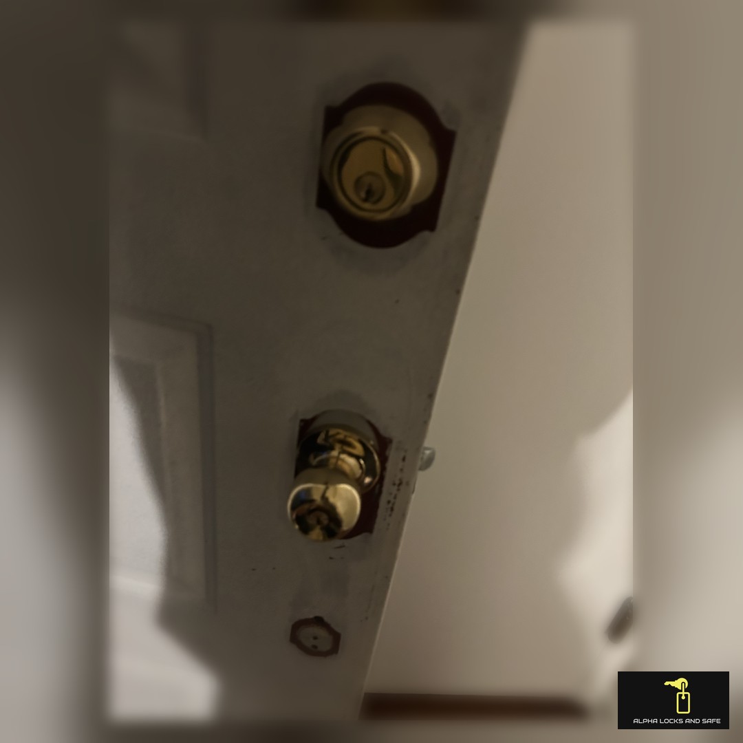 Technician from Alpha Lock and Safe installing a high-security lock on a business door.
